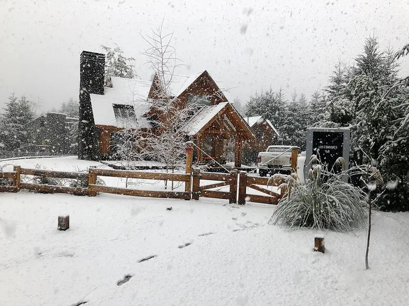 Las cabañas con nieve y la chimenea de piedra