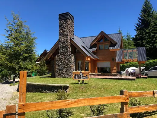 Cabaña con chimenea de piedra y mesa de picnic